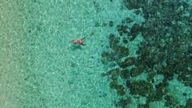 Mercan resifinde yüzen Asyalı kadınlar, Tayland 'ın Trang kentindeki Koh Kradan adasının havadan görünüşü. Mercan resifi ve turkuaz renkli okyanus drone manzaralı tropik plaj.