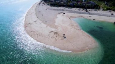 Koh Lipe Tayland 'da tatilde olan bir çift erkek ve kadın güneşli bir günde Koh Lipe' nin mercan kayalığındaki bir kumsalda yürüyorlar.