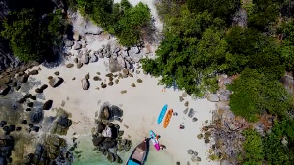 在一个阳光明媚的日子里 一对男女情侣正在Koh Lipe泰国航空度假 他们正在Koh Lipe岛对面的一个神奇的热带海滩上观赏长尾小船和皮划艇 — 图库视频影像