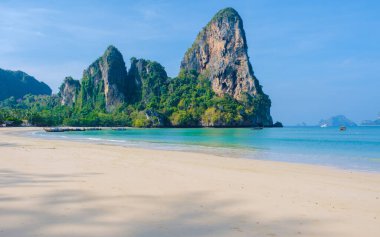 Railay Plajı Krabi Tayland, Tayland 'da geleneksel uzun teknesi ve bulutlu gökyüzü olan huzurlu Railay Krabi' nin tropikal plajı.