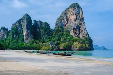 Railay Plajı Krabi Tayland, Tayland 'da geleneksel uzun teknesi ve bulutlu gökyüzü olan huzurlu Railay Krabi' nin tropikal plajı.