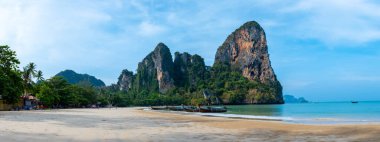 Railay Plajı Krabi Tayland, Tayland 'da geleneksel uzun teknesi ve bulutlu gökyüzü olan huzurlu Railay Krabi' nin tropikal plajı.