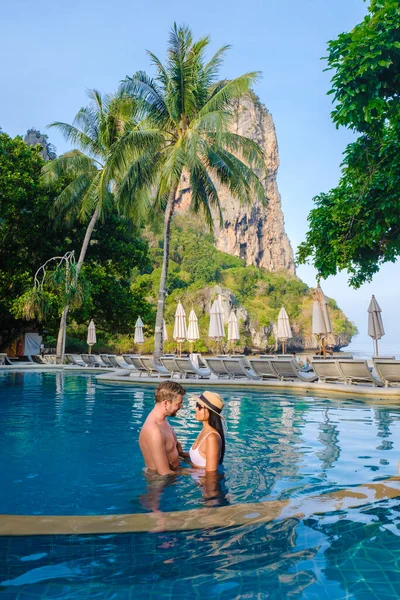 タイの高級リゾートのスイミングプールで男女のカップル レイルビーチの椅子やパラソル付きの高級プール クラビ — ストック写真