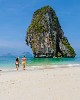 Railay Beach Krabi Tayland, Railay Krabi 'nin tropikal plajı, Krabi Tayland' da tatilde sahilde olan birkaç erkek ve kadın.