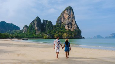 Railay Beach Krabi Tayland, Railay Krabi 'nin tropikal plajı, Krabi Tayland' da tatilde sahilde olan birkaç erkek ve kadın.