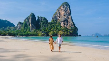 Railay Beach Krabi Tayland, Railay Krabi 'nin tropikal plajı, Krabi Tayland' da tatilde sahilde olan birkaç erkek ve kadın.