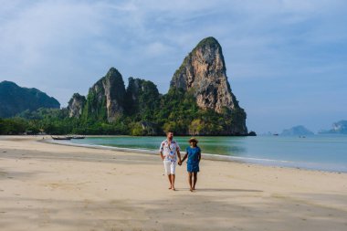 Railay Beach Krabi Tayland, Railay Krabi 'nin tropikal plajı, Krabi Tayland' da tatilde sahilde olan birkaç erkek ve kadın.