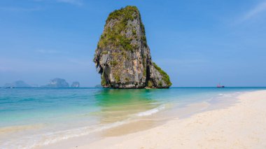 Railay Plajı Krabi Tayland, Tayland 'da geleneksel uzun teknesi ve bulutlu gökyüzü olan huzurlu Railay Krabi' nin tropikal plajı.