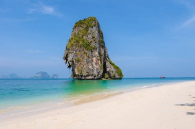 Railay Plajı Krabi Tayland, Tayland 'da geleneksel uzun teknesi ve bulutlu gökyüzü olan huzurlu Railay Krabi' nin tropikal plajı.