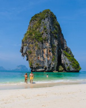 Erkekler ve kadınlar Tayland Railay Plajı 'nda tatil yaparken plajda dinleniyorlar.. 