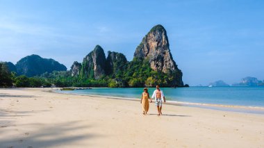 Tayland Railay Plajı 'ndaki bir tatil sırasında kumsalda dinlenen bir çift kadın ve erkek.. 