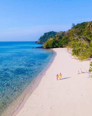 Koh Kradan Adası Güney Tayland dünyanın yeni 1 numaralı plajı seçildi. Koh Kradan 'ın tropikal plajında yürüyen bir çift kadın ve erkek.