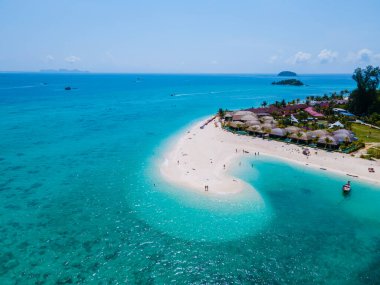 Erkekler ve kadınlar tatil sırasında Koh Lipe Güney Tayland 'da bir kumsalda yürüyorlar..