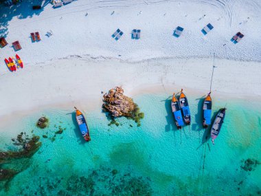 Koh Lipe Satun Tayland 'ın turkuaz renkli okyanusuyla beyaz kumlu sahilde uzun kuyruklu tekneler. Güney Tayland 'da Tropik Plaj