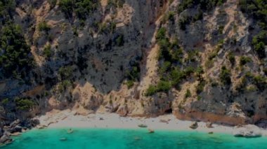 Cala Mariolu Plajı Sardinya İtalya, plaj şemsiyeleriyle dolu güzel bir plaj ve güneşlenen ve turkuaz suda yüzen insanlar. Yaz boyunca Cala Gonone Baunei, Sardinya, İtalya Golfo Di Orosei