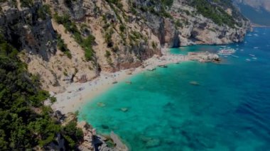 Cala Biriola ve Cala Goloritze, Baunei, Sardinya, İtalya yakınlarındaki Cala Mariolu plajı ve mavi gökyüzü.
