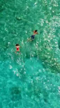 İtalya 'nın Sardunya sahillerinde erkek ve kadınlar, okyanusta kristal mavisi su ile oynayan birkaç erkek ve kadın Cala Luna Sardunya İtalya' da Golfo Di Orosei 'de şnorkelle yüzüyor.