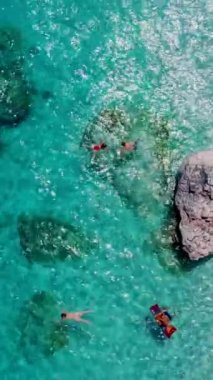 İtalya 'nın Sardunya sahillerinde erkek ve kadınlar, okyanusta kristal mavisi su ile oynayan birkaç kadın ve erkek, Cala Luna Sardunya İtalya' da, Golfo Di Orosei Sardinia 'da şnorkelle yüzüyor.