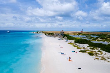 Karayip adası Curacao Karayipleri 'nde tropik plajlı Klein Curacao Adası, turkuaz renkli okyanusları olan bir sahilde insansız hava aracı manzarası ve güneşlenen insanlar.