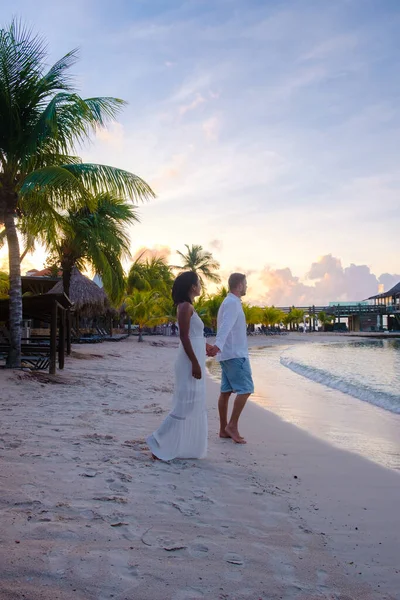 カリブ海での休暇中にキュラソーのビーチでカップル 男性と女性はキュラソーの熱帯ビーチで夕日を見ています — ストック写真