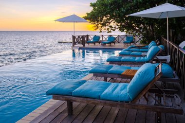 Tatil sırasında Curacao 'da bir havuz kenarında gün batımı. Tropikal bir adada lüks bir tatil. Plaj şezlonglarıyla gün batımı.