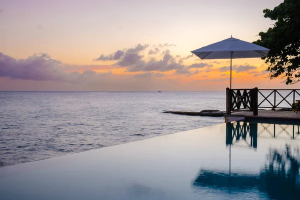 Tatil sırasında Curacao 'da bir havuz kenarında gün batımı. Tropikal bir adada lüks bir tatil. Plaj şezlonglarıyla gün batımı.