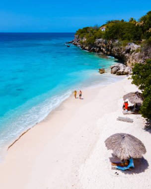 Playa Kalki Plajı Karayip adası Curacao, Playa Kalki Curacao, mavi turkuaz renkli okyanuslu beyaz plaj. Kumsaldaki bir çift kadın ve erkeğin hava görüntüsü.