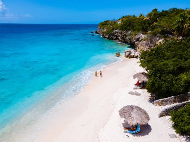 Playa Kalki Plajı Karayip adası Curacao, Playa Kalki Curacao, mavi turkuaz renkli okyanuslu beyaz plaj. Kumsaldaki bir çift kadın ve erkeğin hava görüntüsü.