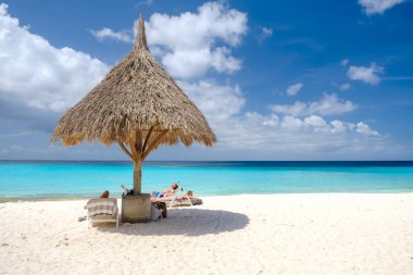Cas Abao Sahili Playa Cas Abao Karayip adası Curacao Mart 2021, Playa Cas Abao Curacao Karayipler 'de tropikal beyaz plaj mavi turkuaz renkli okyanus ve plajda güneşlenen turist