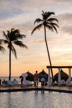 Palm Beach yakınlarında yüzme havuzu olan lüks tatil köyü Aruba Karayipleri, yaz boyunca Karayipler 'de lüks bir tatil yapan orta yaşlı çift.