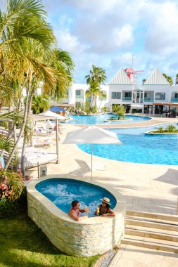 Palm Beach yakınlarında yüzme havuzu olan lüks bir tatil köyü. Karayipler 'de orta yaşlı çift ve erkek.