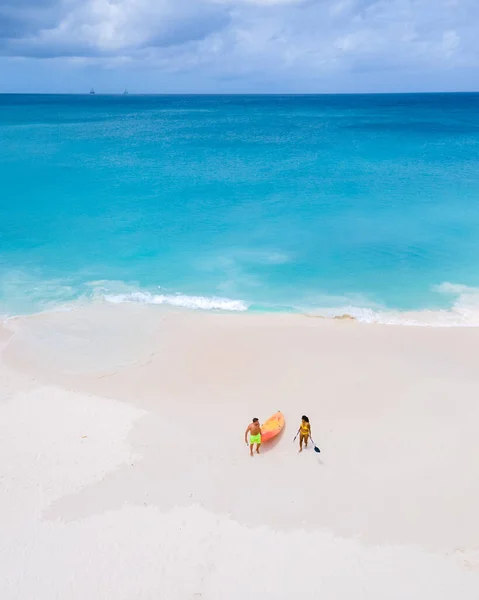 カップルカヤックIn Ocean Vacationアルバカリブ海の海 男と女の中年カヤックIn海の青澄んだ水白いビーチとヤシの木 Aruba — ストック写真