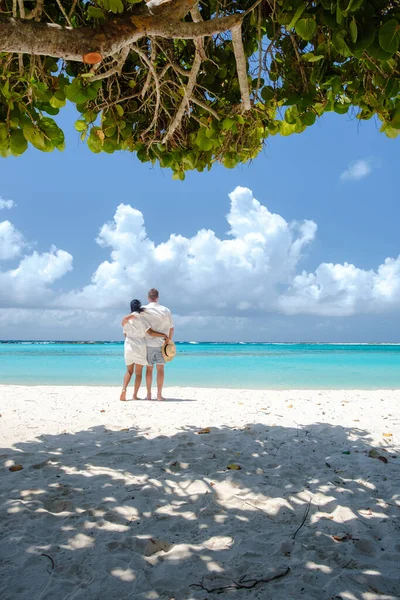 Baby Beach Aruba Adası Karayipleri 'nde birkaç kadın ve erkek. Hollanda Antilleri' nde mavi turkuaz renkli okyanusları olan beyaz bir sahil.