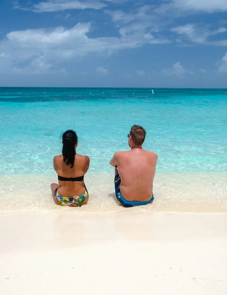 ヤシの木のある白い長い砂浜の男性と女性のカップル Aruba Antillesのヤシの木とターコイズブルーの海 — ストック写真