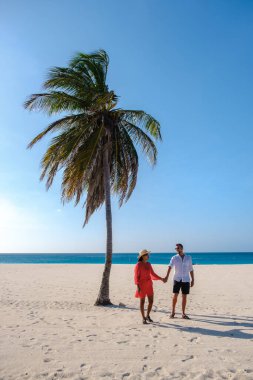 Eagle Beach Aruba, Aruba 'daki Eagle Beach sahilinde Palm Trees, birkaç adam ve Aruba sahilinde bir kadın.