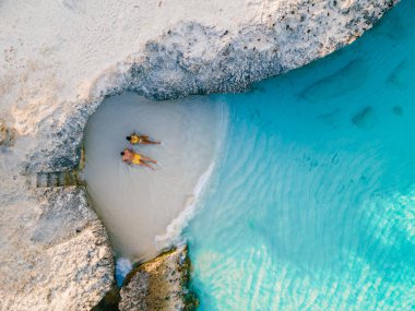 Tres Trap Aruba Karayip Adası sahilinde bir çift kadın ve erkek. Tres Trapi Körfezi yerel halk arasında turkuaz renkli okyanusta dalış ve şnorkelle yüzme konusunda popülerdir.