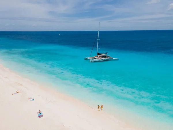 在阳光明媚的日子里 一对男女正在乘船前往小岛库拉索岛 那里有一个白色的海滩和草皮色的大海 — 图库照片