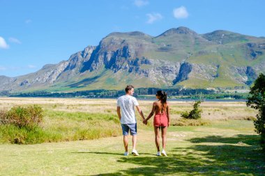 Orta yaşlı bir çift, Güney Afrika 'da tatil yaparken kulübelerinin önünde Hermanus yakınlarındaki Garden Route Western Cape South Africa Sahili' nde dağ ve otlaklar.. 