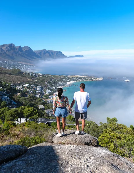 在开普敦坎普斯湾的岩石观景台上 有几个男男女女 他们看到坎普斯湾上空的大雾笼罩着大海 来自南非开普敦坎普湾海域的大雾 — 图库照片