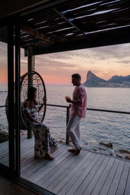 Cape Town Güney Afrika 'da tatilde balkonda gün batımını izleyen çift.. 