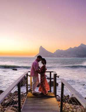 Günbatımında Cape Town Güney Afrika 'da balkonda içki içen çift.. 