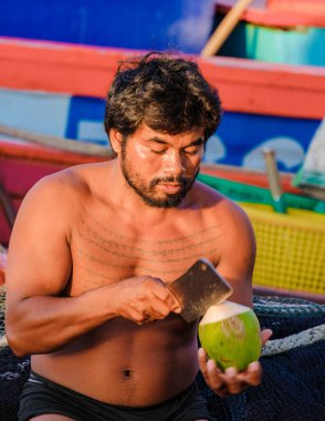 Bangsaray Pattaya Tayland Mayıs 2023 balıkçılar Bangsaray balıkçı köyündeki balıkçı limanında bir bıçakla çiğ hindistan cevizi açtılar.. 