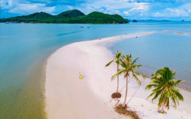 Ada Koh Yao Tayland 'da kumsalda yürüyen bir çift kadın ve erkek. Beyaz kum ve palmiye ağaçları olan bir kumsal..