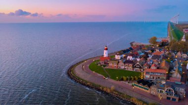 Drone view at Urk Flevoland Netherlands sunset at the lighthouse and harbor of Urk Holland. Fishing village Urk. Beautiful sunset during the evening