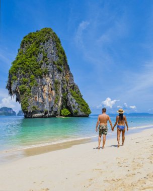 Kumsalda birkaç erkek ve kadın, Tayland 'da geleneksel uzun bir teknesi olan Railay Beach Krabi Tayland' ın tropikal plajı Railay Krabi 'nin manzarası.,