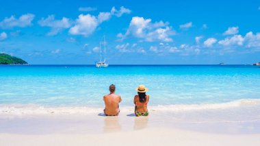 Praslin Seyşeller tropikal adasında plajlar ve palmiye ağaçları var. Seyşeller 'de tatilde olan iki erkek ve kadın. Anse Lazio Praslin Seyşeller' in tropik plajını ziyaret ediyorlar..