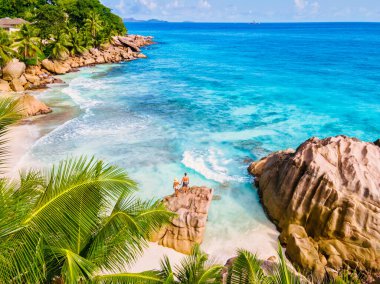 Anse Patates, La Digue Seychelles, Seyşeller 'de lüks bir tatil sırasında tropik bir plajda yaşayan genç bir çift. Tropik sahil Anse Patates, La Digue Seyşeller
