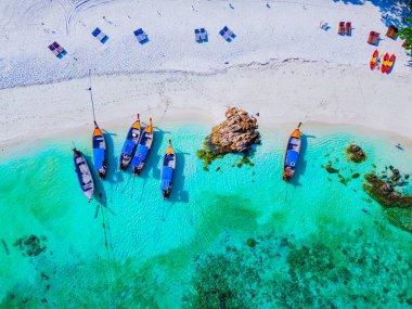 Tayland 'daki Koh Lipe adasının sahilinde drone görüntüsü, Ko Lipe okyanusunda uzun kuyruklu tekneler.