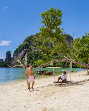 Pakbiya Adası 'ndaki erkekler ve kadınlar Koh Hong Adaları' nın bir parçası olan Krabi Tayland, salıncaklı tropik Krabi plajı.