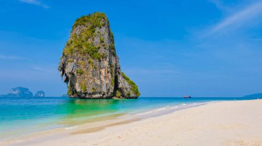 Railay Plajı Krabi Tayland, Tayland 'da geleneksel uzun teknesi ve bulutlu gökyüzü olan huzurlu Railay Krabi' nin tropikal plajı.